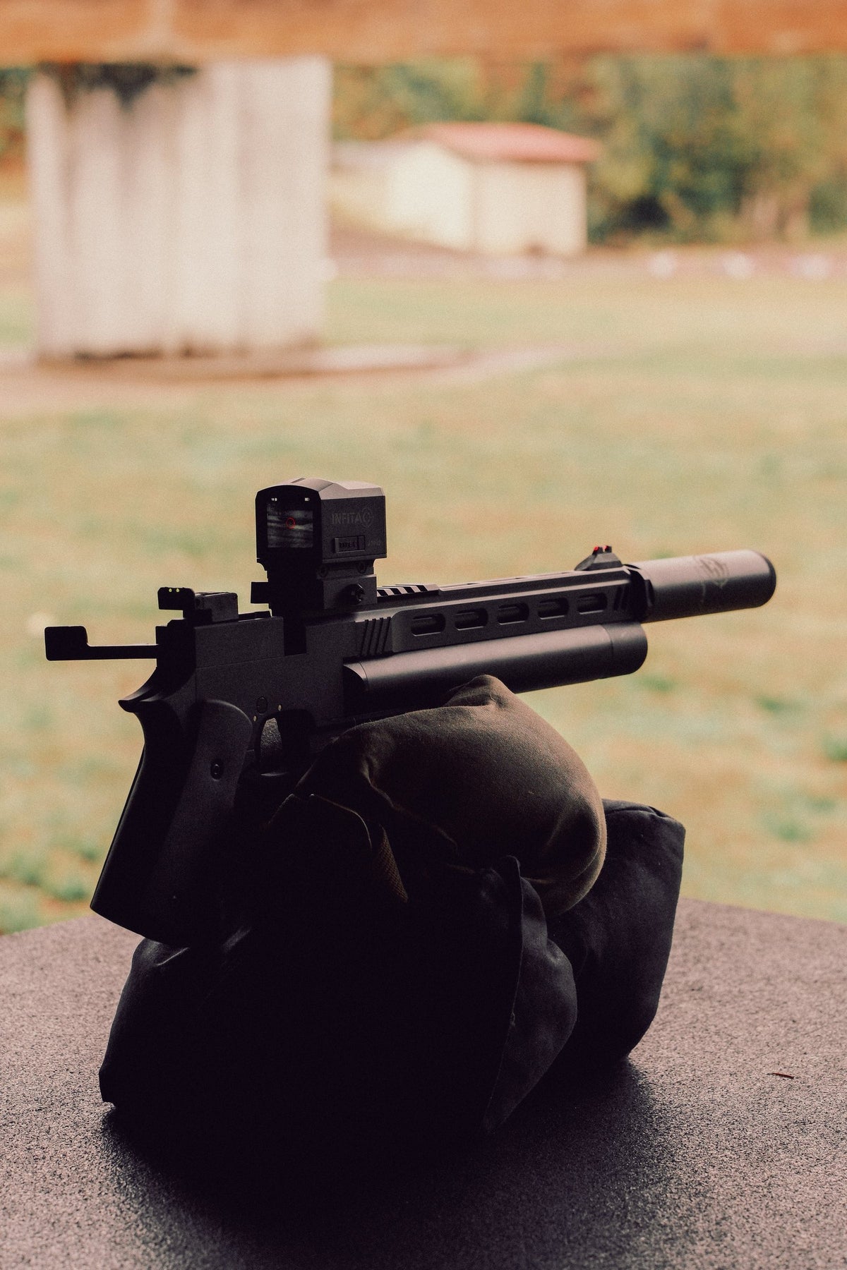 Suppressed air pistol resting on a shooting bag